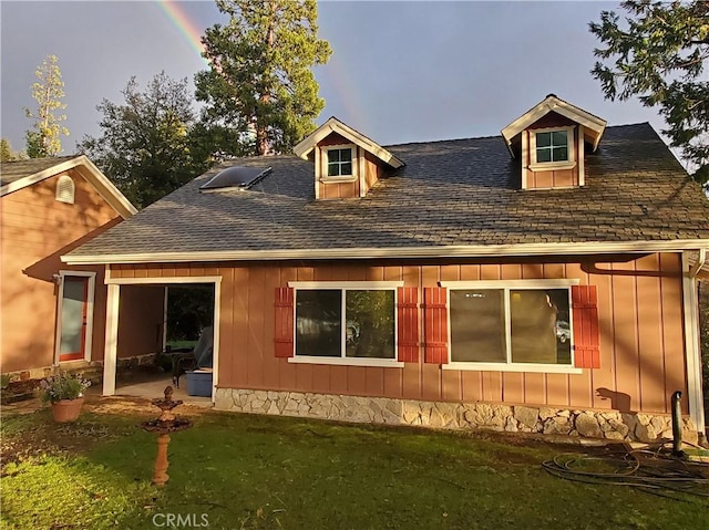 rear view of property featuring a lawn