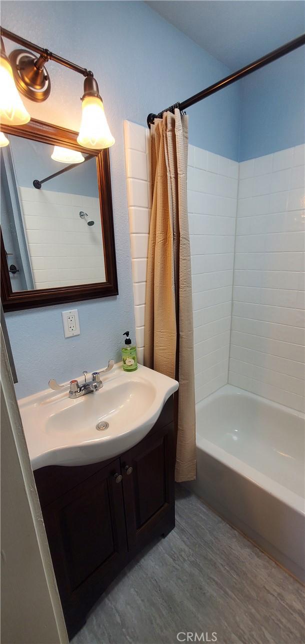 bathroom featuring vanity, shower / bath combination with curtain, and hardwood / wood-style flooring