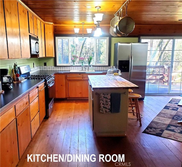 kitchen with sink, light hardwood / wood-style flooring, a healthy amount of sunlight, and black appliances