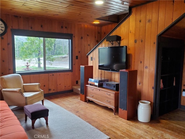 living room with wood walls, light hardwood / wood-style floors, and wooden ceiling