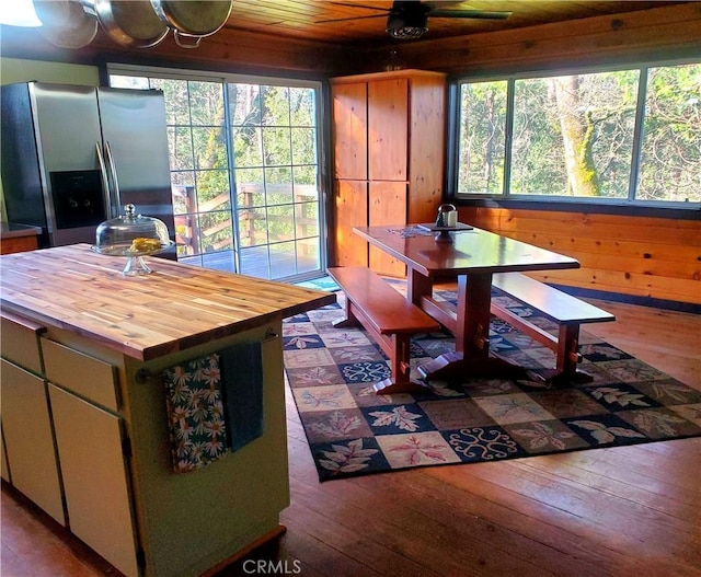 interior space featuring hardwood / wood-style flooring, ceiling fan, wood walls, and wooden ceiling