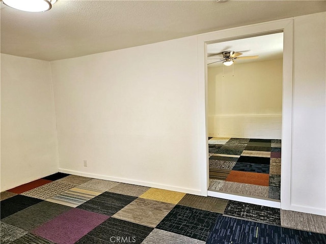 unfurnished room with dark colored carpet and ceiling fan