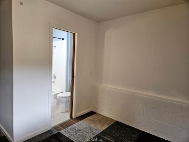 bathroom featuring hardwood / wood-style flooring, toilet, and shower / washtub combination