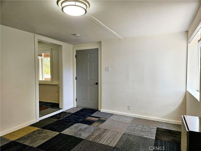 carpeted spare room featuring a textured ceiling