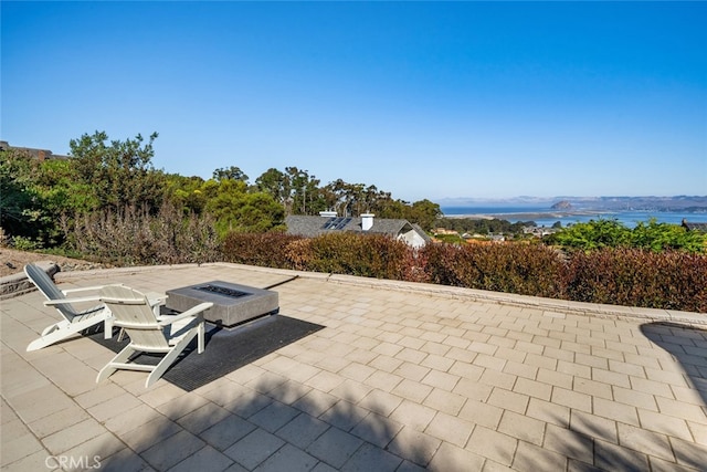 view of patio / terrace with a water and mountain view and an outdoor fire pit