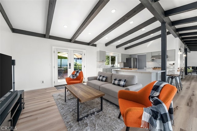 living room featuring light hardwood / wood-style flooring, lofted ceiling with beams, and french doors