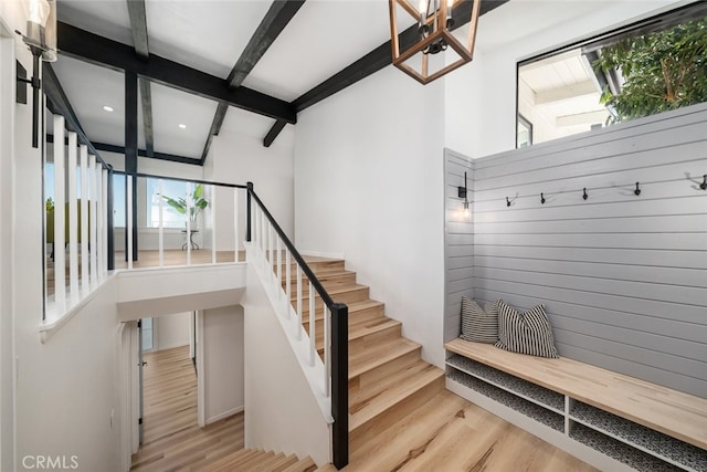 mudroom featuring a high ceiling, light hardwood / wood-style floors, and beamed ceiling