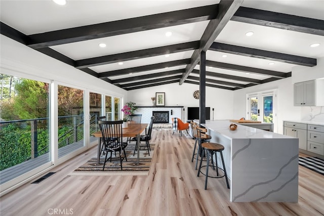 kitchen with a kitchen island, light hardwood / wood-style flooring, gray cabinets, and plenty of natural light