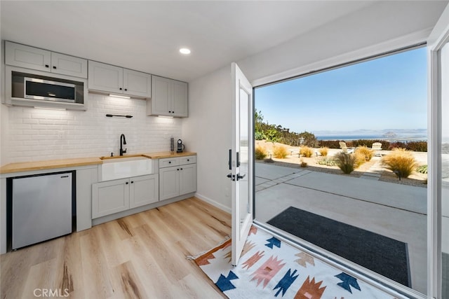 kitchen featuring white cabinets, plenty of natural light, and wood counters