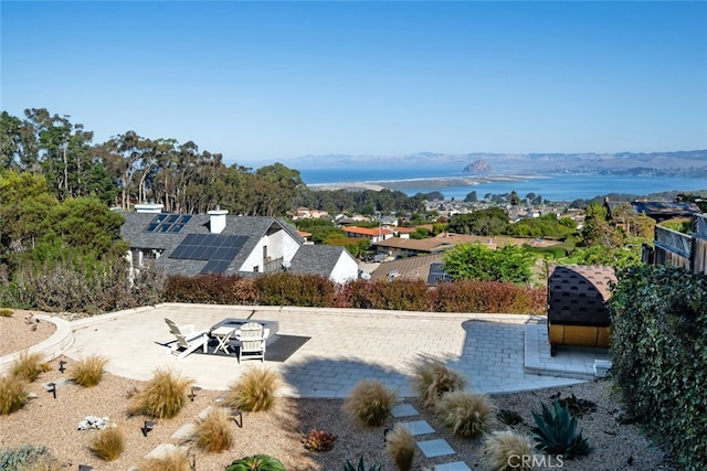 exterior space with a water and mountain view and a patio