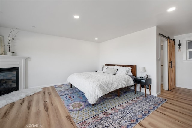 bedroom featuring hardwood / wood-style flooring and a barn door