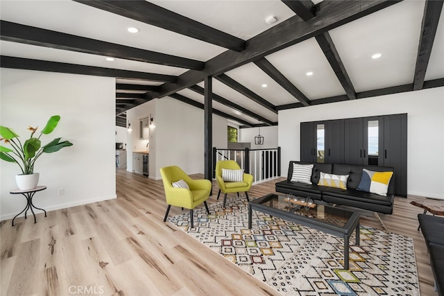 living room featuring light hardwood / wood-style flooring, a wealth of natural light, and lofted ceiling with beams