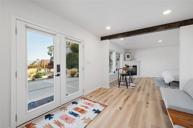 entryway featuring french doors, beamed ceiling, and light hardwood / wood-style flooring