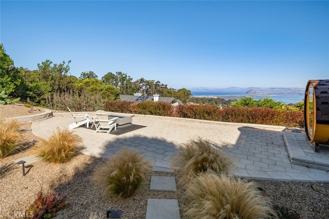 view of community with a patio and a water view