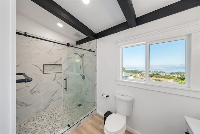 bathroom featuring wood-type flooring, a water view, a shower with door, vanity, and toilet