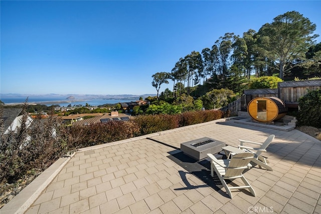 view of patio featuring a water and mountain view and an outdoor fire pit