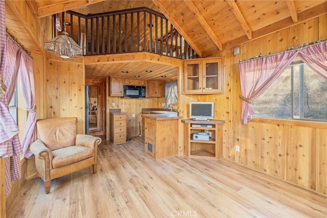 interior space featuring beam ceiling, wooden ceiling, wooden walls, and light hardwood / wood-style floors