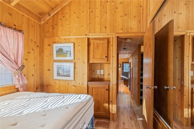 bedroom with wood walls, light hardwood / wood-style floors, and wooden ceiling