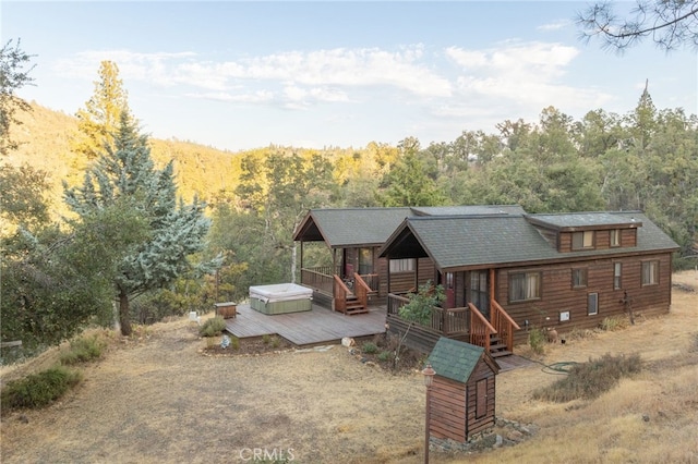 back of house featuring a hot tub and a deck