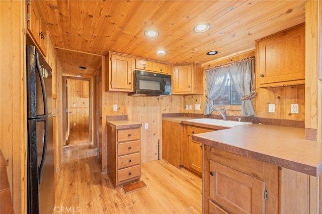 kitchen featuring light hardwood / wood-style floors, sink, wood walls, black appliances, and wooden ceiling