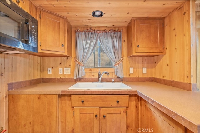 kitchen with sink, wood ceiling, and wood walls