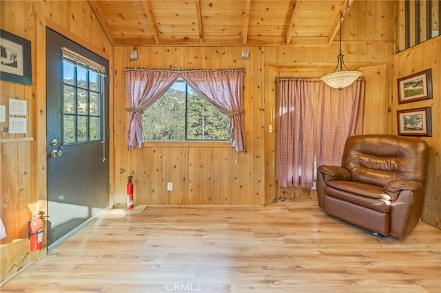 living area featuring vaulted ceiling with beams and wood walls