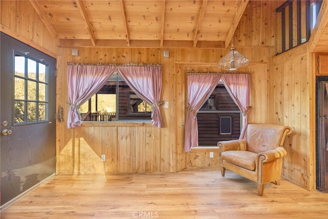 living area featuring lofted ceiling with beams, wood-type flooring, wooden ceiling, and wooden walls