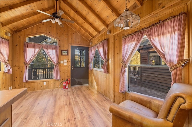 interior space with lofted ceiling with beams, wooden ceiling, wooden walls, and light hardwood / wood-style floors