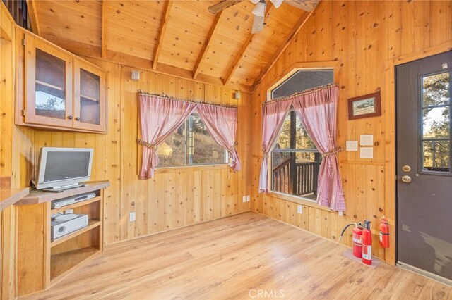 interior space featuring vaulted ceiling with beams, wood ceiling, light hardwood / wood-style flooring, and wood walls