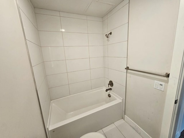 bathroom featuring tiled shower / bath, tile patterned floors, and toilet