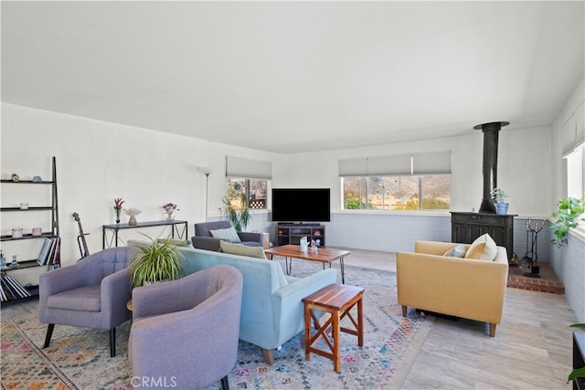 living room with light hardwood / wood-style floors and a wood stove