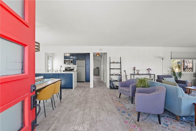 living room featuring light hardwood / wood-style floors and sink