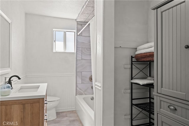 full bathroom featuring vanity, shower / tub combo, toilet, and a textured ceiling