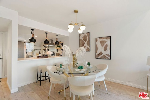 dining space featuring a notable chandelier and light wood-type flooring