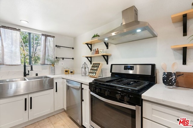 kitchen with light stone countertops, ventilation hood, stainless steel appliances, sink, and white cabinetry