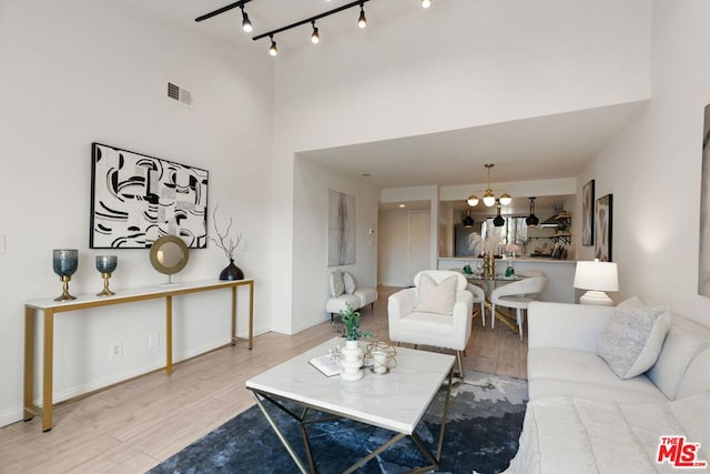 living room featuring a chandelier, hardwood / wood-style floors, and a high ceiling