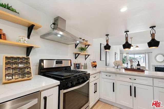 kitchen featuring stainless steel appliances, light stone counters, pendant lighting, extractor fan, and white cabinets