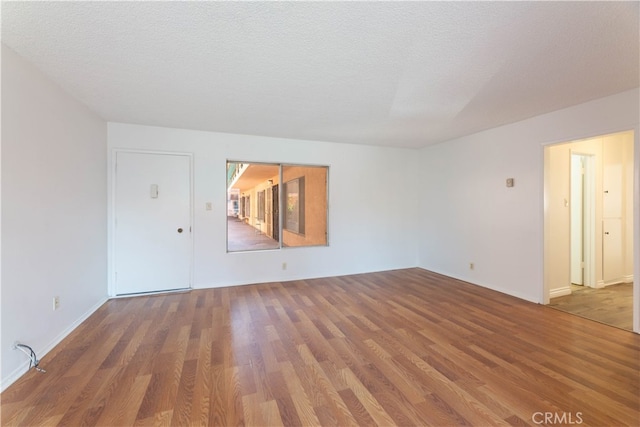 unfurnished room featuring hardwood / wood-style floors and a textured ceiling