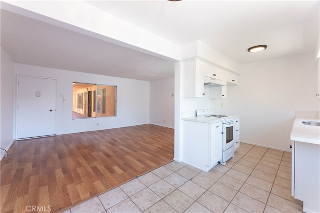 kitchen with white cabinets, light wood-type flooring, white electric stove, and sink