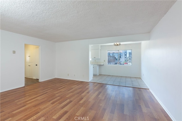 unfurnished living room featuring a textured ceiling and hardwood / wood-style flooring