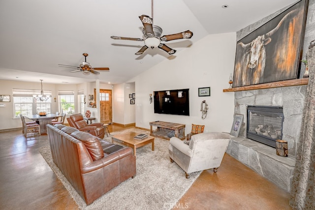 living room with ceiling fan with notable chandelier, lofted ceiling, and a fireplace