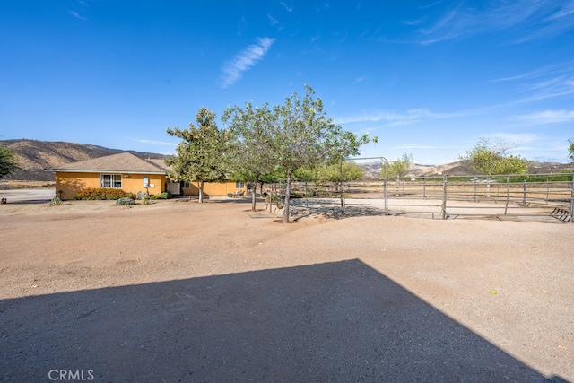 view of yard with a rural view and a mountain view