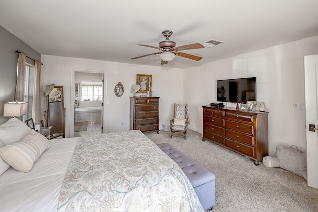 carpeted bedroom featuring ensuite bath and ceiling fan