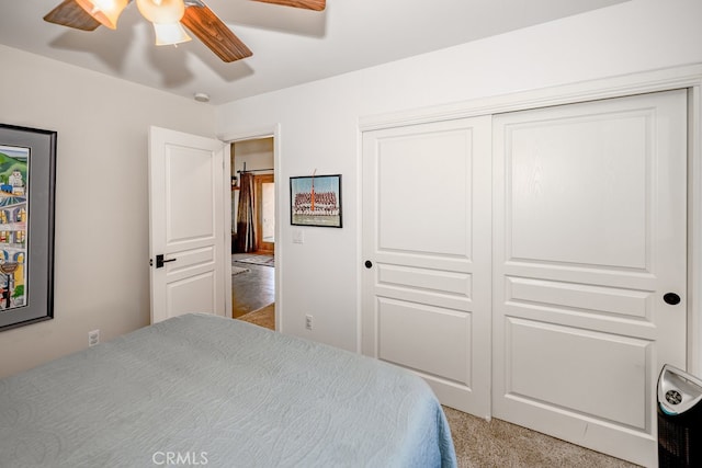 bedroom with ceiling fan, a closet, and carpet flooring