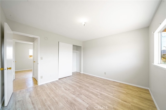 unfurnished bedroom featuring light wood-type flooring and a closet