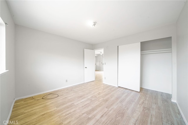 unfurnished bedroom featuring light wood-type flooring and a closet