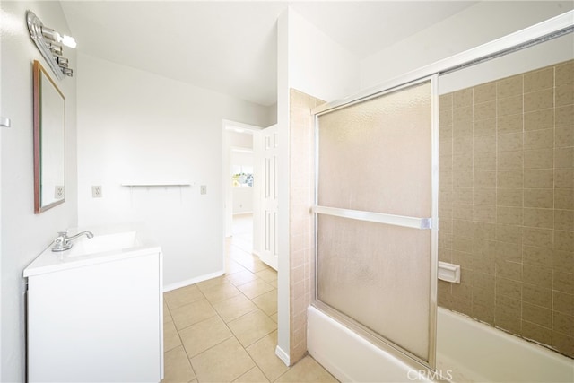 bathroom featuring tile patterned flooring, vanity, and combined bath / shower with glass door