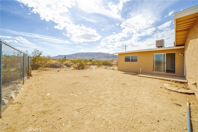 view of yard with a mountain view and central AC unit