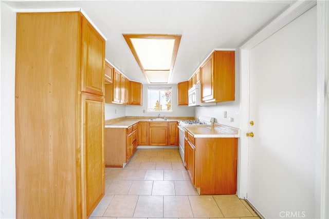 kitchen featuring white appliances, light tile patterned flooring, and sink