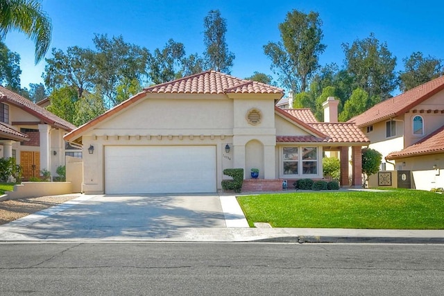 mediterranean / spanish-style home with a garage and a front yard